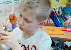 Uczeń klasy 1a podczas twórczej pracy_przygotowanie doniczek.