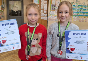 Uczennice klasy 2a z pamiątkowymi dyplomami oraz medalami.