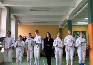 Pamiątkowe zdjęcie szermierzy z trenerem.