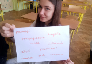 Uczennica prezentująca pracę związaną z poległymi w Katyniu.