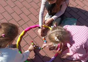 Twórcze aktywności związane z Dniem Kropki_zabawa z wykorzystaniem kolorowych pomponów i hula-hop.