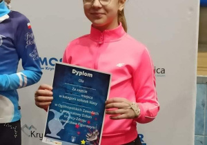 Zawodniczka pokazuje dyplom.