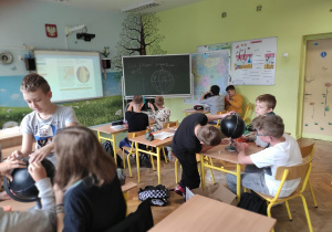 Uczniowie klasy 6b podczas pracy z globusem indukcyjnym