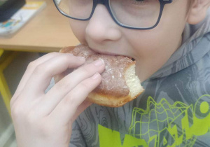 Uczeń klasy 3b delektujący się pączkiem.