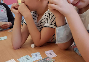 Dzieci grają w grę stolikową.