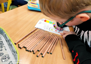 Uczeń podczas pracy z materiałami związanymi z Dniem Kolorowej Skarpetki.