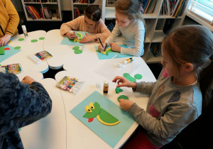 Uczniowie klasy 1a podczas twórczej pracy_wykonanie smoka z kolorowych kółek.