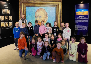 Uczniowie klasy 1a z wychowawcą na tle obrazu "Autoportret" Vincenta Van Gogha.