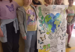 Uczniowie klasy 2a prezentujący plakat dotyczący obchodów Dnia Ziemi.