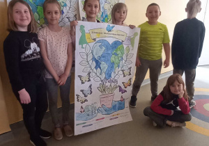 Uczniowie klasy 2a prezentujący plakat dotyczący obchodów Dnia Ziemi.