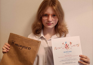 Uczennica klasy VIIa, Sara Grabicka z dyplomem i nagrodami za zajęcie II miejsca.