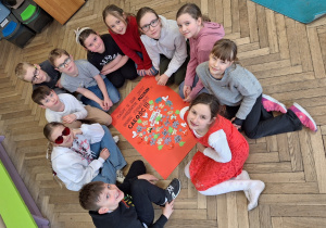 Klasowe obchody walentynkowe w klasie 3a_uczniowie prezentujący plakat z puzzli.
