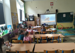 Świetliczaki oglądający wiosenną prezentację tematyczną.