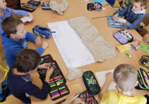 Uczniowie klasy 1b podczas przygotowywania swojej pracy_ogólnopolski konkurs plastyczny pt. "Kot Pupik i szalona jazda"_