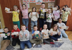 Finał ogólnopolskiego konkursu plastycznego pt. "Kot Pupik i szalona jazda"_uczniowie klasy 1b prezentujący nagrody.