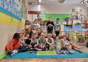 Poranki poetyckie w klasie 1a_bliskie spotkanie z bajkoterapią w ramach projektu "Postaw na wartości"_zdjęcie grupowe z wychowawczynią, p. A. Tarajkowską.