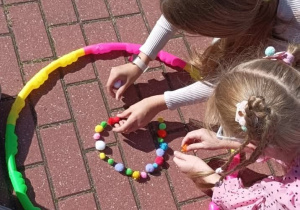 Twórcze aktywności związane z Dniem Kropki_zabawa z wykorzystaniem kolorowych pomponów i hula-hop.