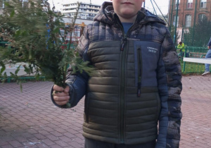 Dary jesieni i ich kreatywne wykorzystanie_uczeń prezentujący zebrane dary.