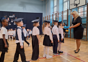 Uroczyste ślubowanie uczniów klas pierwszych_moment pasowania na ucznia szkoły przez Panią Dyrektor Monikę Siedmiogrodzką.
