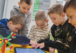 Uczniowie klasy 1a podczas warsztatów robotycznych "Projektujemy komPAKTowego robota".