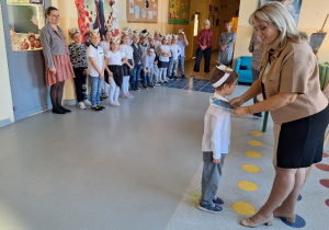 Uroczyste pasowanie pierwszoklasistów na Czytelnika_moment uroczystego pasowania na czytelnika przez Panią Dyrektor Monikę Siedmiogrodzką.