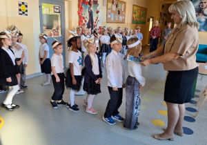 Uroczyste pasowanie pierwszoklasistów na Czytelnika_moment uroczystego pasowania na czytelnika przez Panią Dyrektor Monikę Siedmiogrodzką.