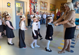 Uroczyste pasowanie pierwszoklasistów na Czytelnika_moment uroczystego pasowania na czytelnika przez Panią Dyrektor Monikę Siedmiogrodzką.