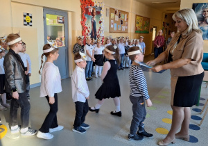 Uroczyste pasowanie pierwszoklasistów na Czytelnika_moment uroczystego pasowania na czytelnika przez Panią Dyrektor Monikę Siedmiogrodzką.