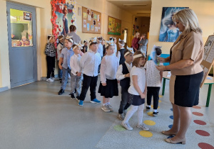 Uroczyste pasowanie pierwszoklasistów na Czytelnika_moment uroczystego pasowania na czytelnika przez Panią Dyrektor Monikę Siedmiogrodzką.