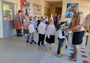 Uroczyste pasowanie pierwszoklasistów na Czytelnika_moment uroczystego pasowania na czytelnika przez Panią Dyrektor Monikę Siedmiogrodzką.