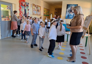 Uroczyste pasowanie pierwszoklasistów na Czytelnika_moment uroczystego pasowania na czytelnika przez Panią Dyrektor Monikę Siedmiogrodzką.