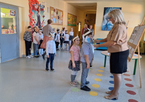 Uroczyste pasowanie pierwszoklasistów na Czytelnika_moment uroczystego pasowania na czytelnika przez Panią Dyrektor Monikę Siedmiogrodzką.