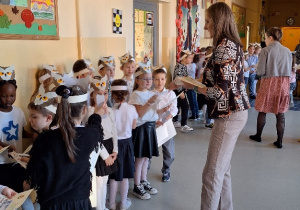 Uroczyste pasowanie pierwszoklasistów na Czytelnika_moment wręczenia pamiątkowych dyplomów i zakładek.