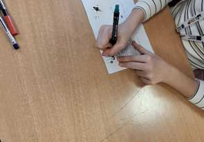 Uczniowie piszą kartki.