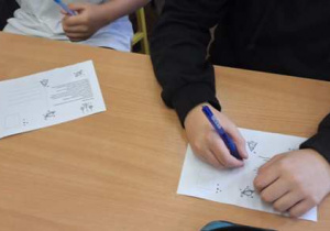 Uczniowie piszą kartki.