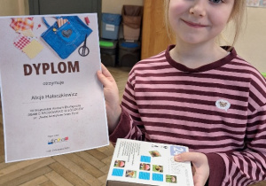 VII Wojewódzki Konkurs Ekologiczny "Dbam o środowisko w łódzkiem"_uczennica prezentująca dyplom i nagrodę rzeczową.