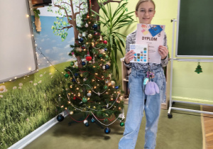 VII Wojewódzki Konkurs Ekologiczny "Dbam o środowisko w łódzkiem"_uczennica prezentująca dyplom i nagrodę rzeczową.