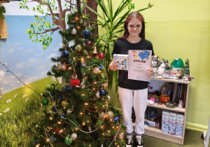 VII Wojewódzki Konkurs Ekologiczny "Dbam o środowisko w łódzkiem"_uczennica prezentująca dyplom i nagrodę rzeczową.