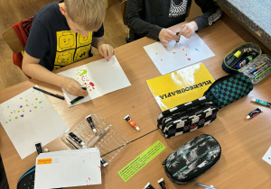 Kreatywne podsumowanie lektury w klasie 4a_uczniowie uczestniczący w wyjątkowych lekcjach kleksografii, przędzenia liter i geografii.