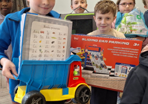 Wiosenna akcja "Dzień bez plecaka"_projektowo w klasie 1a_uczniowie prezentujący swoje pojemniki na książki.