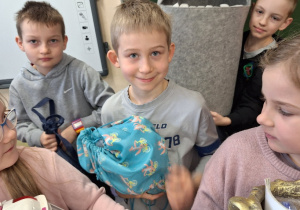 Wiosenna akcja "Dzień bez plecaka"_projektowo w klasie 1a_uczniowie prezentujący swoje pojemniki na książki.