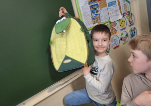 Wiosenna akcja "Dzień bez plecaka"_projektowo w klasie 1a_uczeń prezentujący swój pojemnik na książki.