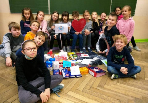 Uczniowie klasy 3a prezentują zgromadzone dary.