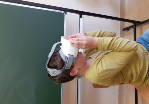 Chłopiec ma na głowie okulary do wirtualnej rzeczywistości.