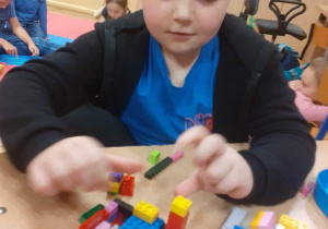 Uczeń klasy 1b podczas twórczej pracy z klockami LEGO.
