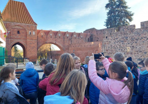 Uczniowie podziwiający Krzywą Wieżę w Toruniu.