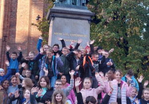 Uczniowie przed pomnikiem Mikołaja Kopernika.