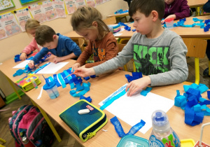Uczniowie klasy 1a podczas procesu farbowania papieru bibułą.