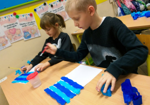 Uczniowie klasy 1a podczas procesu farbowania papieru bibułą.