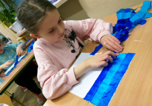 Uczennica klasy 1a podczas procesu farbowania papieru bibułą.